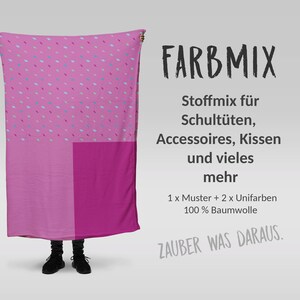 Könnte beinhalten: Ein rosa Stoff mit einem Muster aus kleinen blauen und rosa Strichen und einem einfarbigen rosa Quadrat. Der Text "FARBMIX" wird in Schwarz angezeigt, zusammen mit deutschem Text, der die Verwendung des Stoffes beschreibt, einschließlich Accessoires und Kissen. Der Stoff ist 100 % Baumwolle.