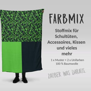 Könnte beinhalten: Ein rechteckiger Stoff mit einem grün-schwarzen Pixelmuster oben und einem durchgehenden grünen und marineblauen Abschnitt unten. Der Text "FARBMIX" wird in großen schwarzen Buchstaben angezeigt, mit zusätzlichem Text darunter.