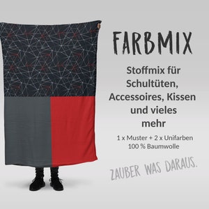 Könnte beinhalten: Eine Person hält ein dunkelblaues und rotes Stoffstück mit geometrischem Muster hoch. Der Stoff ist mit "FARBMIX Stoffmix für Schultüten, Accessoires, Kissen und vieles mehr 1 x Muster + 2 x Unifarben 100% Baumwolle ZAUBER WAS DARAUS." beschriftet.