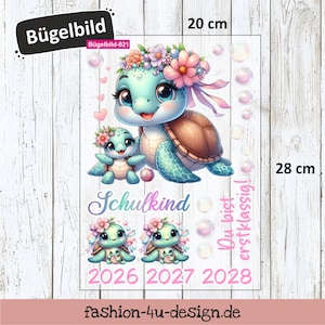 Könnte beinhalten: Ein Bügelbild mit einer Cartoon-Schildkrötenfamilie mit Blumenstirnbändern. Das Design enthält den Text "Schulkind" und "Du bist erstklassig!". Das Bügelbild misst 20 cm breit und 28 cm hoch.