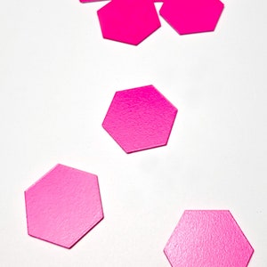 May include: A collection of pink hexagonal paper shapes scattered on a white surface. The text "FX BSDESIGN" is visible in the bottom right corner of the image.