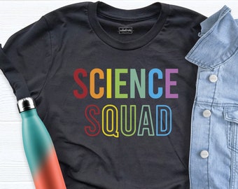 May include: A black t-shirt with the text "SCIENCE SQUAD" in rainbow colours. The text is outlined in white.