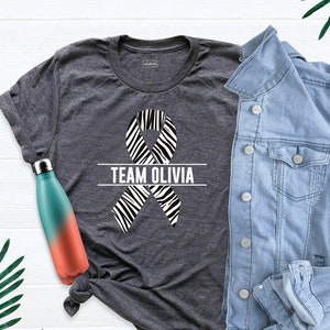 Camisetas del equipo de apoyo contra el cáncer carcinoide, camiseta con lazo de cebra, camiseta de concientización sobre el cáncer neuroendocrino, camiseta personalizada contra el cáncer, camiseta de guerrero carcinoide