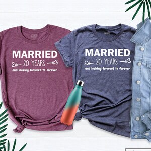 May include: Two t-shirts with the text "Married 20 Years and looking forward to forever" in white text on a maroon and a navy blue shirt.