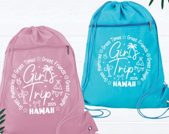 Op de afbeelding: Twee trekkoordrugzakken, één roze en één blauw, met de tekst "Girl's Trip Hawaii 2025" in het wit. De tassen hebben een ritsvak en een trekkoord. Het ontwerp bevat palmbomen, sterren en de woorden "Great Times, Great Friends, Great Laughs, Memories".