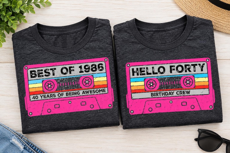 Pu&ograve; includere: Due magliette grigio scuro a girocollo con una grafica a cassetta retr&ograve;. La maglietta a sinistra riporta il testo BEST OF 1986 e 40 YEARS OF BEING AWESOME. La maglietta a destra riporta il testo HELLO FORTY e BIRTHDAY CREW in rosa, giallo e blu.
