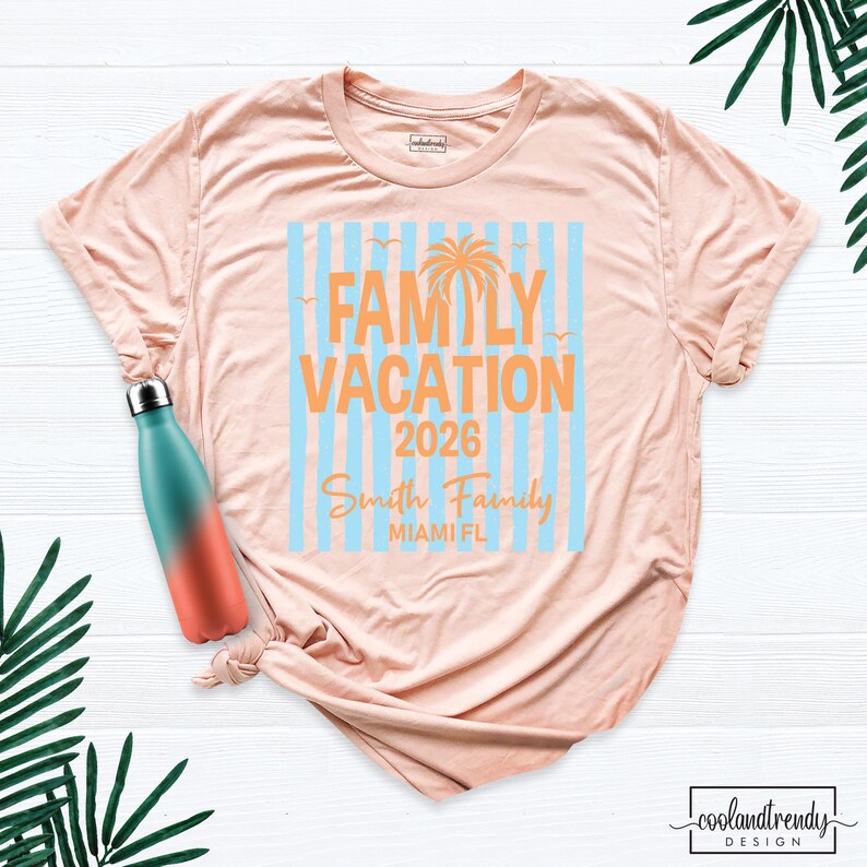 May include: A peach-colored t-shirt featuring a graphic with light blue vertical stripes, an orange palm tree, and the text "FAMILY VACATION 2026 Smith Family MIAMI FL". A teal and orange gradient water bottle is positioned on the shirt.