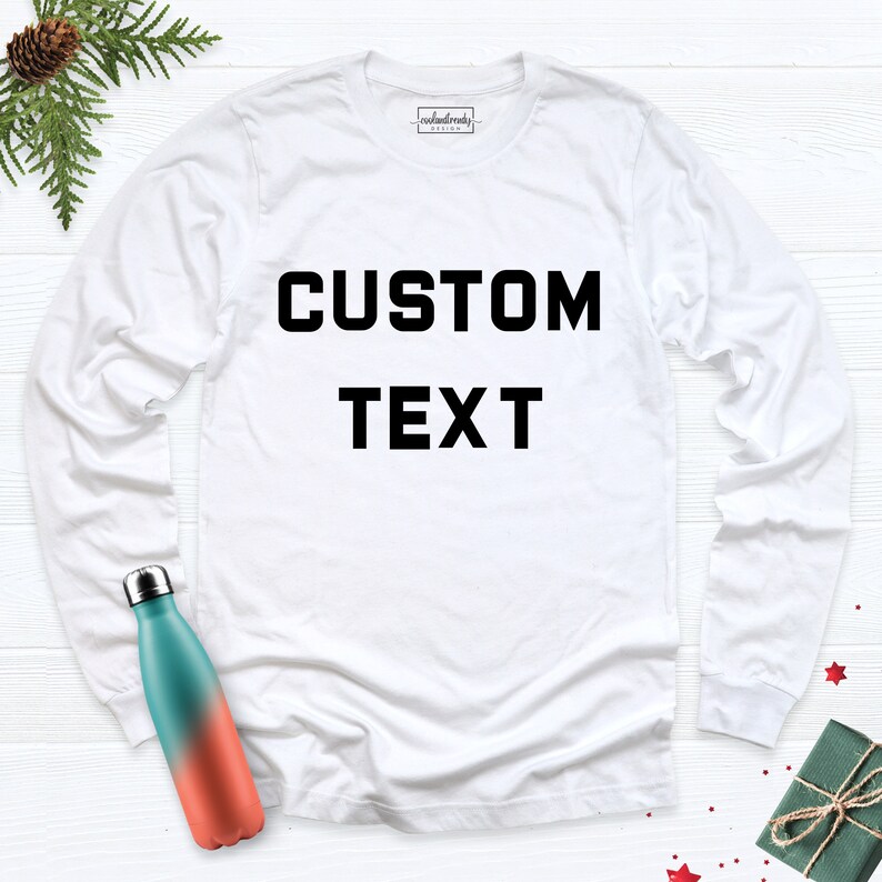 K&ouml;nnte beinhalten: Wei&szlig;es Langarmshirt mit schwarzem Text, der "CUSTOM TEXT" lautet.
