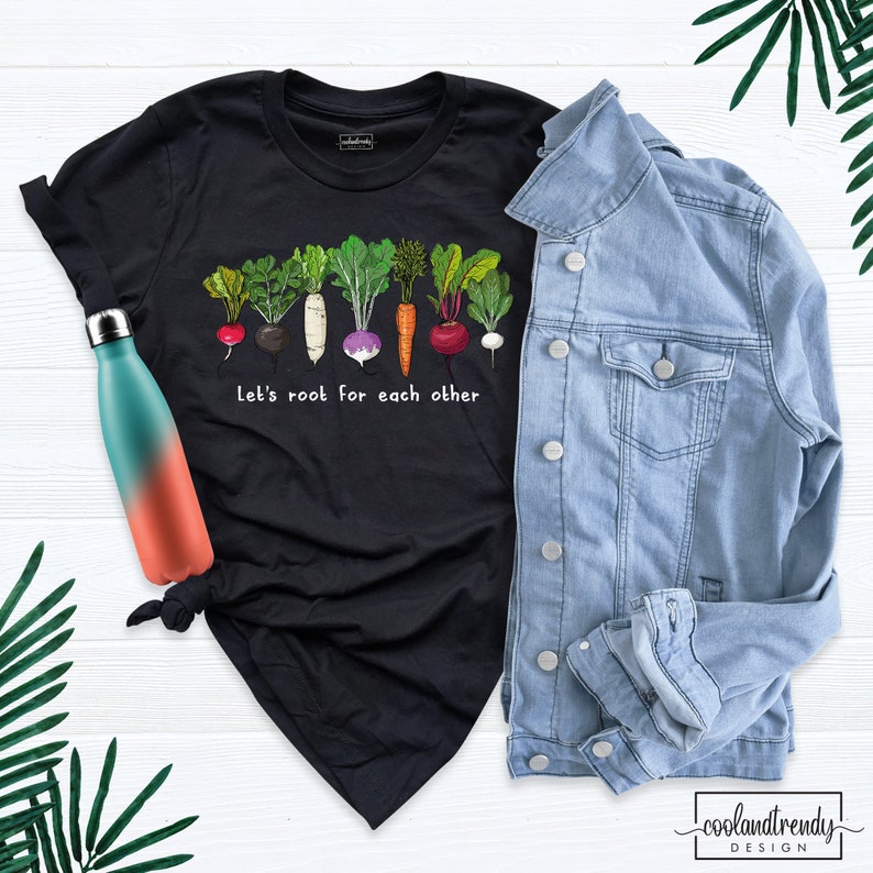May include: Black t-shirt with a line of colorful vegetables and the text "Let's root for each other".