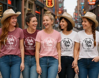 May include: Five women wearing cowboy hats and matching t-shirts with the text "Girls Trip 2024" in a circular design. The shirts are various colors, including maroon, pink, and white, paired with blue jeans. The group is smiling and standing on a city street.