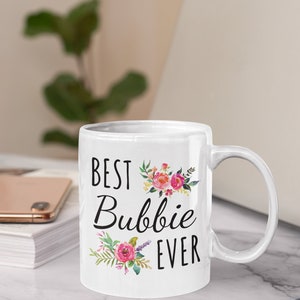 May include: White ceramic mug with a black floral design and the text "Best Bubbie Ever".