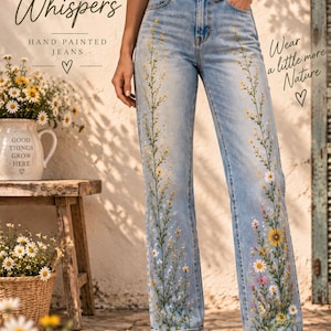 Könnte beinhalten: Hellblaue Jeans aus Denim mit handgemalten Blumenmotiven aus gelben, weißen und rosa Wildblumen, die sich über die Vorderseite beider Beine erstrecken. Die Jeans hat eine hoch taillierte Passform, einen Knopf- und Reißverschluss und weiße Sneaker.