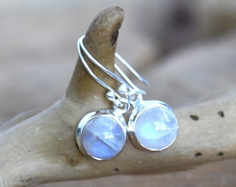 May include: A pair of silver dangle earrings with round, iridescent moonstone gemstones.