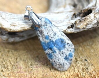 May include: A silver pendant with a blue and white speckled stone. The stone is teardrop shaped and has a silver bail.