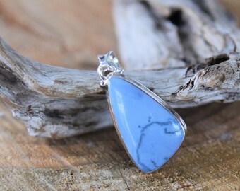 May include: A light blue gemstone pendant with a silver bail. The pendant is shaped like a teardrop and has a natural, organic look. The gemstone has a light blue color with white veins running through it.