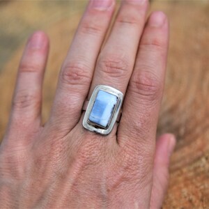 May include: A silver ring with a rectangular blue opal stone set in a silver bezel.