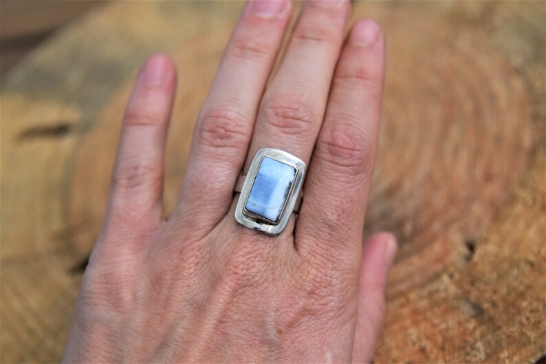 May include: A silver ring with a rectangular blue opal stone set in a silver bezel.