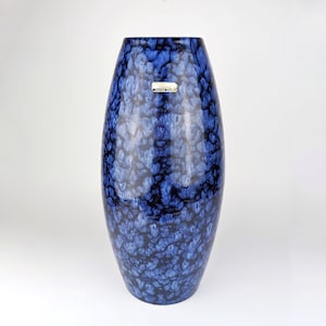 Könnte beinhalten: Eine blaue und weiße Keramikvase mit einer marmorierten Glasur. Die Vase ist oval geformt und hat ein Etikett mit der Aufschrift "Handwerk, Schweden, 1960er Jahre".