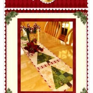 May include: A patchwork Christmas tree table runner with green, red, and white fabric. The runner is on a wooden table with a vase of candy canes and a red poinsettia.