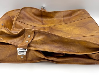 Vintage brown faux leather garment bag is a 1970s American Tourister suit bag.