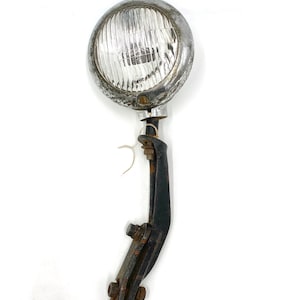 May include: A vintage chrome car spotlight with a clear glass lens and a black metal mounting bracket.