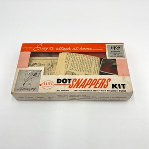 May include: A vintage box of Dritz Laundryproof Dot Snappers Kit. The box is red and white with the text "Easy to attach at home" and "$1.00 Complete Attaching Tools and 10 Complete Snappers". The box also has the text "DOT SNAPPERS KIT NO SEWING... THEY GO ON IN A JIFFY - WITH PRECISION TOOLS".