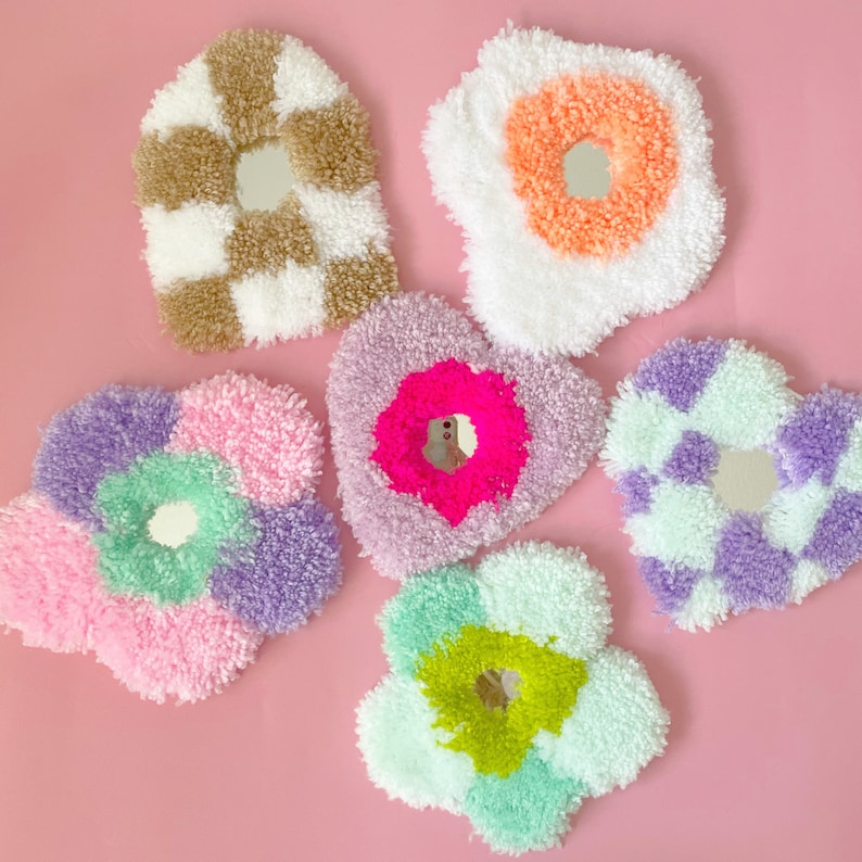 Puede incluir: Cinco piezas de decoraci&oacute;n de pared redondas, esponjosas y coloridas con espejos en el centro. Cada pieza tiene una forma y un color diferentes, incluyendo un coraz&oacute;n, una flor y un patr&oacute;n a cuadros.