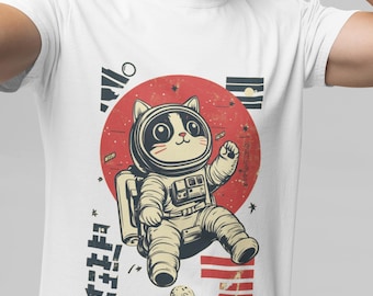 以下が含まれることがあります： 宇宙猫のイラストがプリントされた白いTシャツ。猫は宇宙服を着て、赤い太陽と星の前で浮いている。