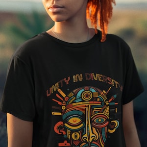Puede incluir: Camiseta negra con un gráfico colorido de una cara estilizada y el texto "Unity in Diversity, Strength in Color".