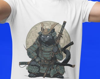 May include: White t-shirt featuring a black cat in samurai armor, holding a katana and other swords. The cat is set against a circular background with a detailed design. The design is in shades of green, brown, and gray.
