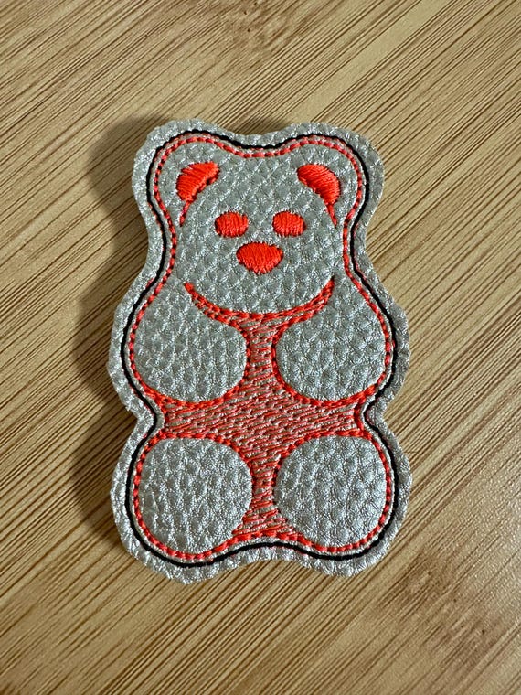 メタリックゴールドのフェイクレザーとフェルトに刺繍されたフェルティ