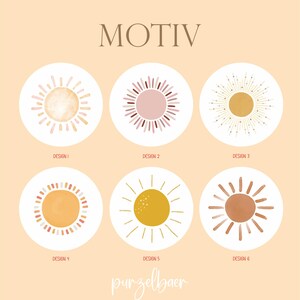 May include: A collection of six sun designs in a variety of styles and colors, each within a white circle. The word "MOTIV" is at the top, and the brand name "purzelbaer" is at the bottom. The designs include watercolor and graphic styles.