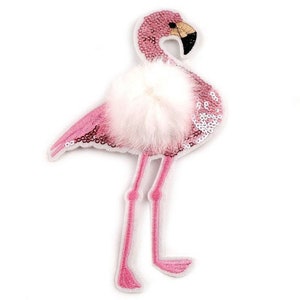 Könnte beinhalten: Rosafarbener Flamingo-Patch mit weißem, flauschigem Bommel und glitzernden Pailletten.