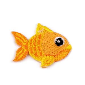 Könnte beinhalten: Ein kleiner, orangefarbener und gelber gestickter Fisch mit einem schwarzen Auge. Der Fisch ist ein niedliches Design im Cartoon-Stil.