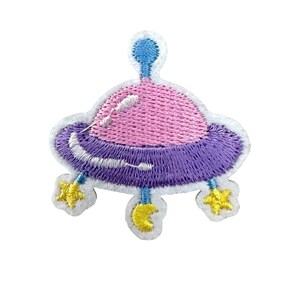 Könnte beinhalten: Gestickter Aufnäher mit einem Cartoon-UFO in Rosa, Lila, Blau und Gelb. Das UFO hat eine rosa Oberseite, eine lila Basis und gelbe sternförmige Akzente. Der Aufnäher ist weiß umrandet.