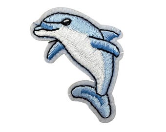 Könnte beinhalten: Gestickter Aufnäher mit einem hellblauen und weißen Delfin, der aufspringt. Der Delfin hat ein detailliertes Stichdesign mit einem grauen Rand. Geeignet für Kleidung, Taschen oder andere Stoffartikel.