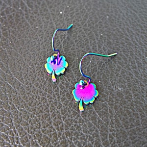 Peut inclure: Une paire de boucles d'oreilles trèfle arc-en-ciel irisées avec une fermeture à crochet.
