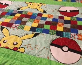 May include: A green, yellow, and red patchwork quilt with a Pikachu and Pokeball design. The quilt features a variety of fabrics, including polka dots, stripes, and floral patterns.