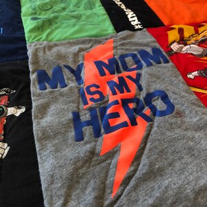 May include: A gray t-shirt with an orange lightning bolt graphic and the text "My Mom Is My Hero" in blue.