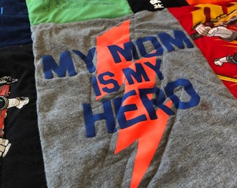 May include: A gray t-shirt with an orange lightning bolt graphic and the text "My Mom Is My Hero" in blue.