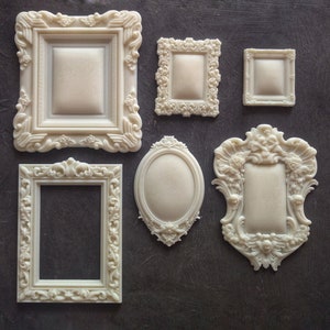 May include: Set of six white ornate picture frames in various sizes and designs. The frames are made of a smooth, white material and have a vintage, antique look.