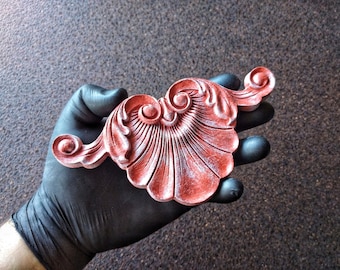 May include: A decorative, ornate, red and white, plaster, wall decor piece with a scalloped design.
