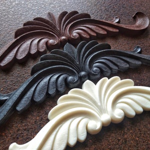 Peut inclure: Trois moulures murales décoratives de différentes couleurs : marron, noir et blanc. Chaque moulure présente un motif floral stylisé avec des détails complexes.