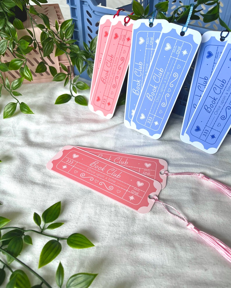 May include: Four pink and blue bookmark designs with a ticket shape and the text "Book Club" and "Once upon a time".