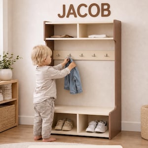 May include: A cream and brown wooden entryway storage unit featuring a top shelf, a middle section with five metal hooks, and a bottom bench with two open cubbies. The word JACOB is mounted on the wall above the unit. The text THIS LISTING PHOTO HAS CREAM AND BROWN COLORS is printed at the bottom.