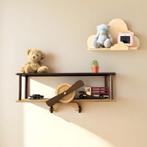 May include: Wooden airplane shelf with a brown finish. The shelf has two levels and features a propeller, a toy truck, and a teddy bear.