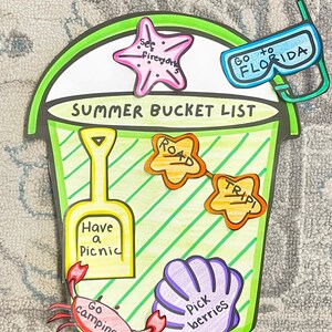 May include: A green bucket with a white interior and a green handle. The bucket has a list of summer activities written on it, including "Go camping", "Pick berries", "Have a picnic", "See fireflies", "Go to Florida", "Road trip".