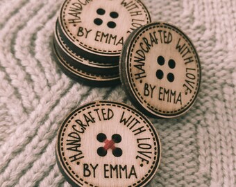 May include: Close-up of three wooden buttons with the text "Handcrafted with Love. By Emma" engraved on them. The buttons have a red thread sewn through the center hole.
