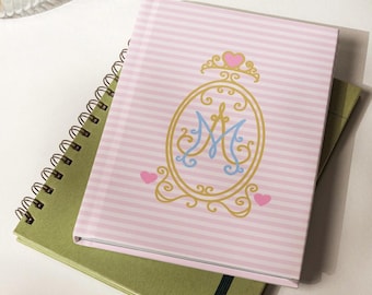 Caderno de Maria Católica com texto de Ave Maria no verso e Opulent Auspice M na frente