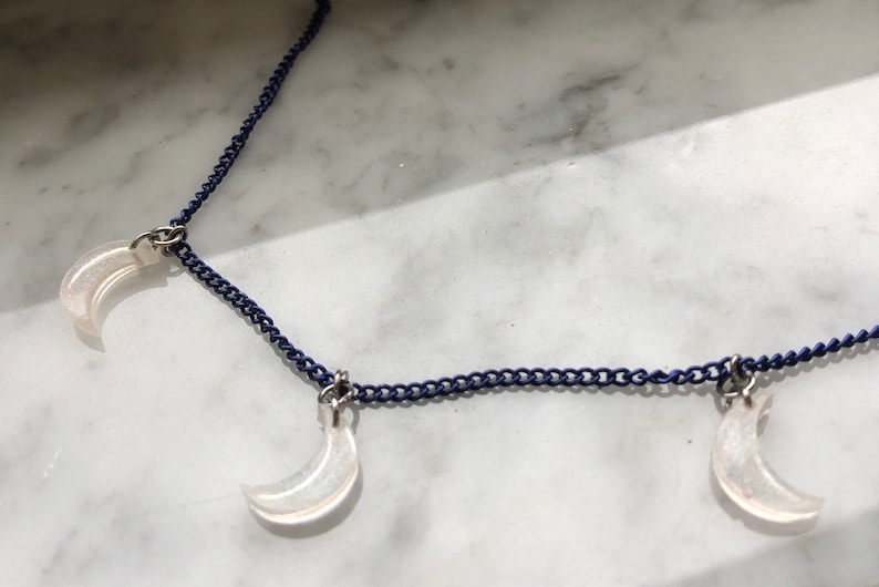 light pink glitter moons on a navy blue chain